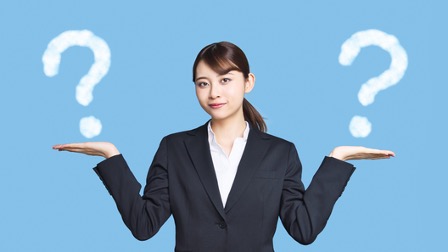 両手を天秤のように見立てて立っているスーツの女性。両手の上にはクエスチョンマークのイラスト。