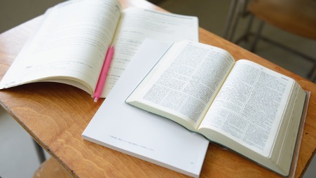 机の上の参考書。国家資格の勉強をしているイメージ。