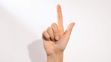 上の方を指さしている人の手。柔道整復師の年収をアップする方法。